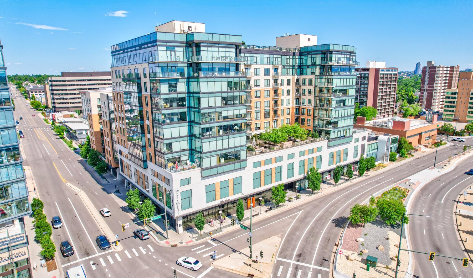 a large building with many windows in front of an intersection of roads