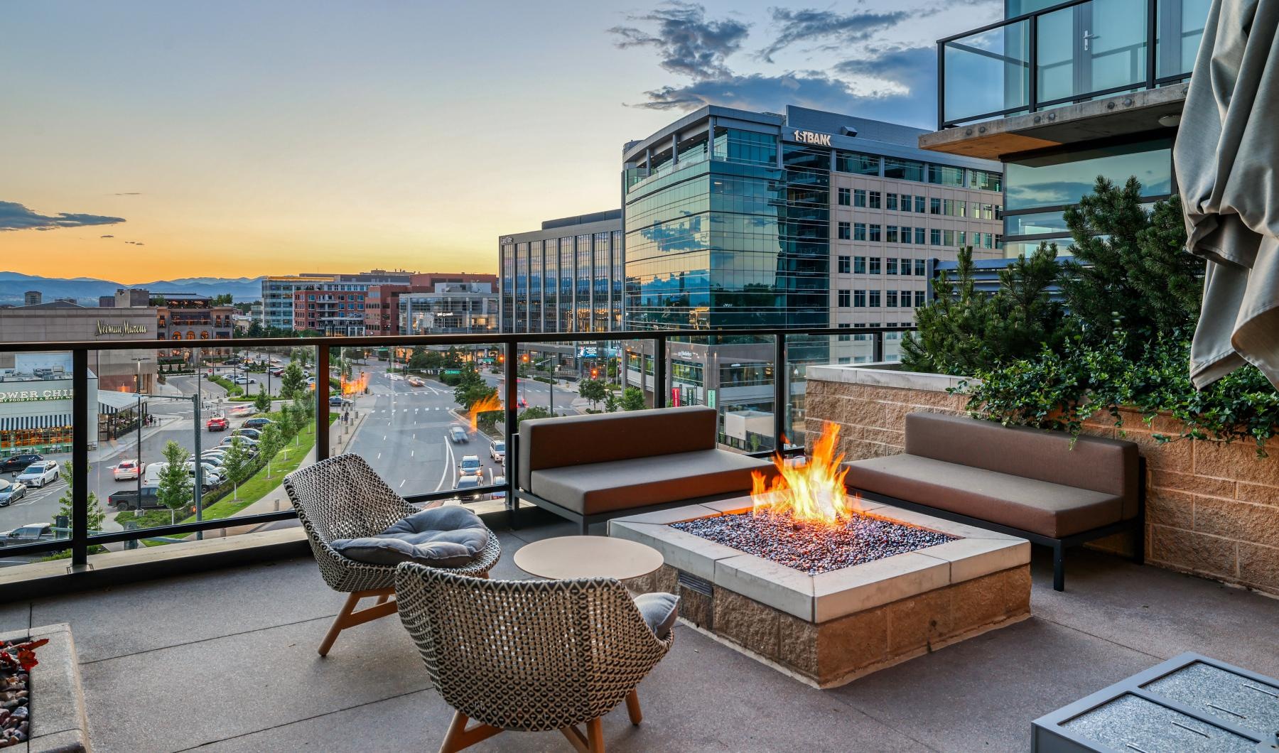a fire pit with chairs and a view of a city