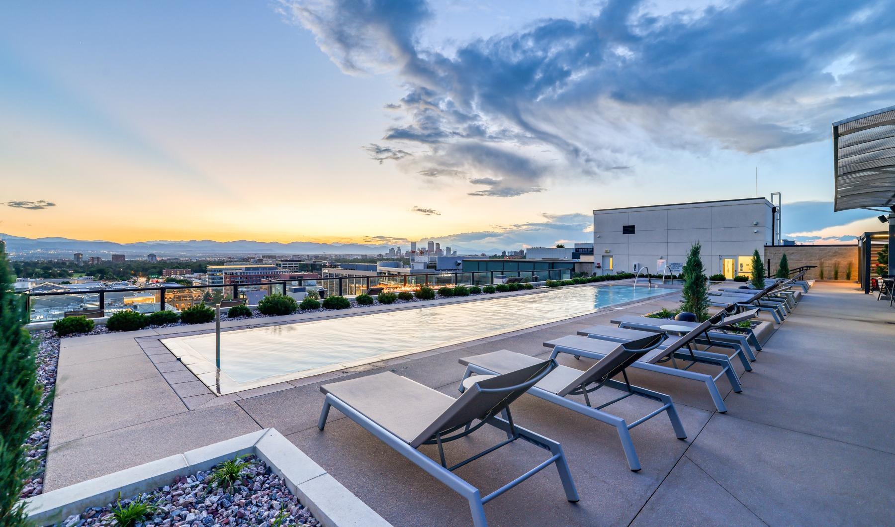 a pool and chairs outside overlooking a city