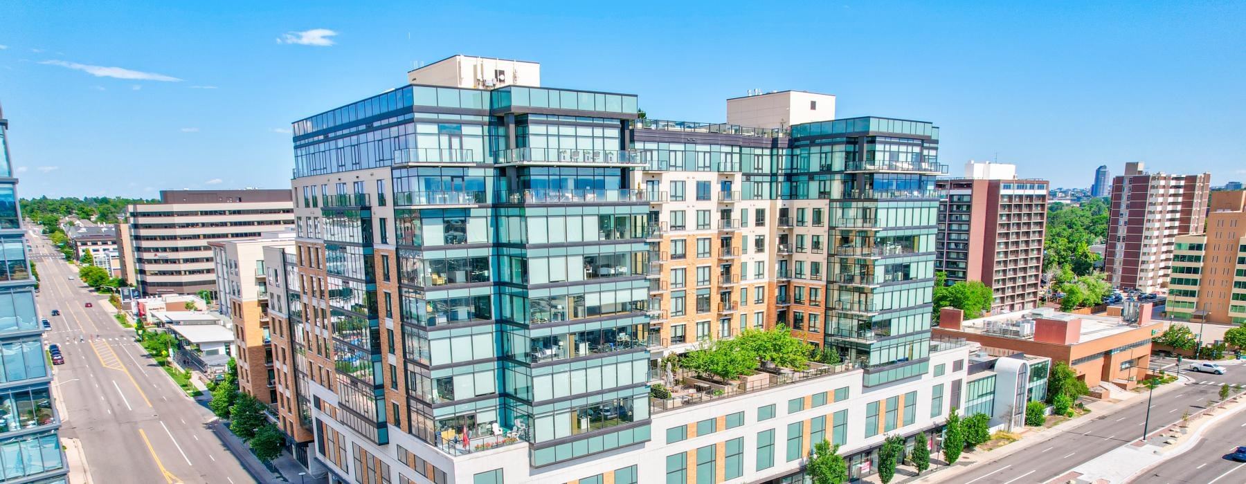 a large building with many windows in front of an intersection of roads
