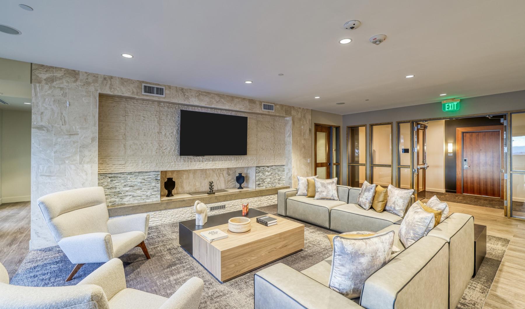 a lounge with a tv and couches and tables