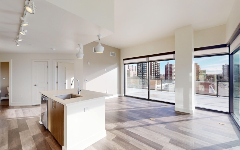 an empty kitchen and living room with large windows